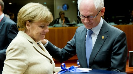 Den tyske kansler Angela Merkel overrækker en afskedsgave til nu afgåede formand for Det Europæiske Råd, Herman Van Rompuy. 