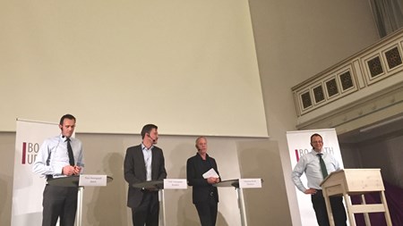 Christian Kettel Thomsen er første departementschef på talerstolen under Bo Smith-udvalgets debatarrangement mandag aften. Fra venstre ses også departementscheferne Peter Steensgaard Mørch og Ulrik Vestergaard Knudsen.