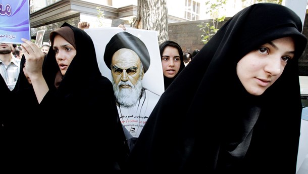 Iranske demonstranter med en plakat af den iranske revolutions leder, Ayatollah Khomeini, protesterer ved den schweiziske ambassade mod en film, der latterliggør profeten Muhammed (sept. 2012).