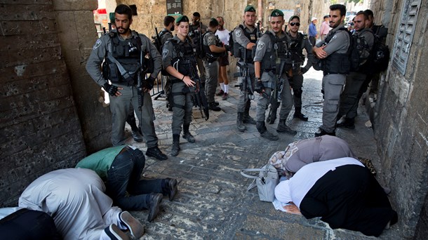 Palæstinensere i bøn, mens det israelske grænsepoliti holder vagt ved Løveporten i Jerusalems gamle bydel.