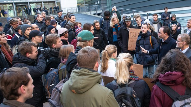 Uddannelses- og forskningsminister Tommy Ahlers (V) omringet af udenlandske studerende foran AAU, efter at universitetet har meldt ud, at de vil lukke uddannelserne ned. (Arkivfoto) 