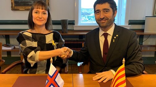 Færøernes finansminister, Kristina Háfoss, og Cataloniens minister for digitalisering og offentlig administration, Jordi Puigneró, giver hånd på samarbejdsaftalen mellem de to territorier. 