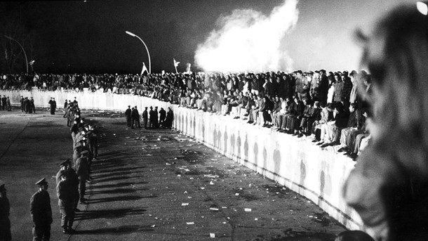 Tusindvis er samlet på Berlinmuren ved Brandenburger Tor i Vestberlin 10. november 1989, dagen efter den østtyske regering åbnede grænsen. På østsiden står politiet klar.