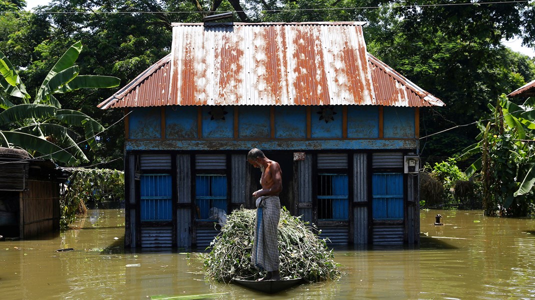 Arkivfoto: En mand står på sin båd, efter at hans hun er blevet oversvømmet i Munshiganj-distriktet i udkanten af Dhaka, Bangladesh. Rige lande som Danmark har lovet at hjælpe fattige lande med at håndtere konsekvenserne af klimaforandringer.