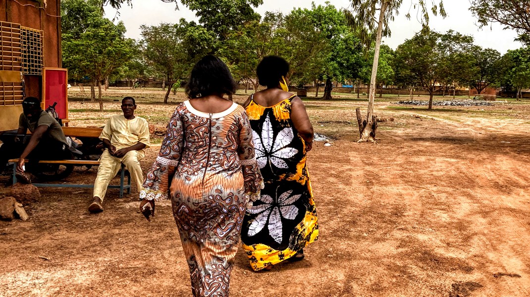 Lederen af sundhedsklinikken CSPS i Ouagadougou, Marie Madeleine Ilboudo, går forrest i sort og gul kjole under en rundvisning.