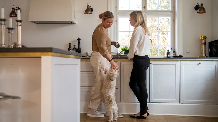 Henriette Kinnunen og Marina Veligura står i køkkenet og bruger samtalekort, som de hygger sig med engang imellem.