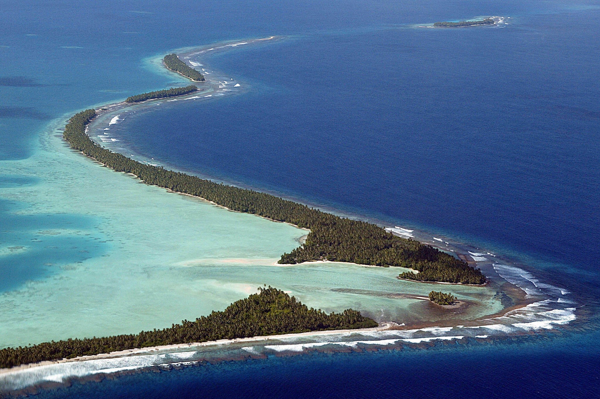 Luftfoto af en af atollerne, der udgør østaten Tuvalu, fra 2004. Atoller er ringformede øer, der består af koralrev på randen af tidligere vulkanøer. 