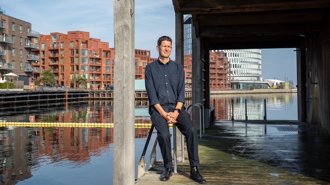 Lars Jensen ved kajkanten i Nordhavn, hvor bygningerne spejler sig i vandet. Han spillede en afgørende rolle i udformningen af det nye kvarter på Østerbro igennem 15 år som arkitekt i arkitektvirksomheden Sleth og rådgiver for byudviklingsselskabet By og Havn. Nu har han overtaget stolen som stadsarkitekt i København.